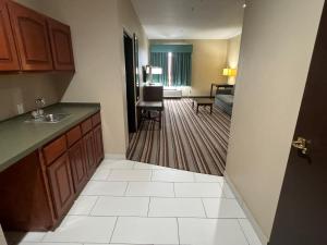 a kitchen with a sink and a living room at Super 8 by Wyndham Port Arthur/Nederland Area in Port Arthur