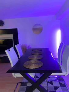 a purple dining room with a black table and white chairs at Innenstadt - 5 Min. vom Bahnhof. in Villingen-Schwenningen