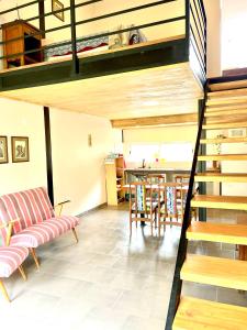 a living room with a staircase and a table and chairs at LOFT JUJUY, Alto Gorritti - Departamento cerca del Centro in San Salvador de Jujuy
