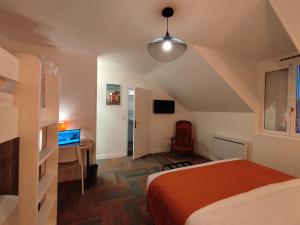 a bedroom with a bed and a desk with a computer at The Originals Access, Hotel Le Canter Saumur in Saumur