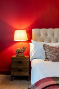 a bed with a nightstand with a lamp on it at The Bull on the Green in Newick