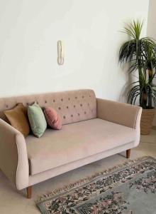 ein Sofa im Wohnzimmer mit Kissen drauf in der Unterkunft Appartement fonctionnel proche de tout in Tunis