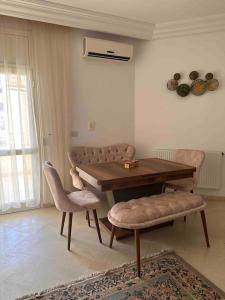 ein Esszimmer mit einem Holztisch und Stühlen in der Unterkunft Appartement fonctionnel proche de tout in Tunis