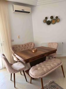 einen Esstisch mit 2 Stühlen und einem Tisch in der Unterkunft Appartement fonctionnel proche de tout in Tunis
