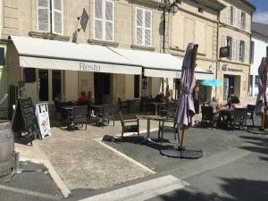 un tavolo con ombrellone davanti a un ristorante di La Maison Saint Pierre, Aulnay ad Aulnay