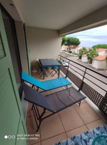 een balkon met 2 stoelen en een tafel. bij T2 2/6 p Clim vue mer piscine parking privé tout à pied in Collioure