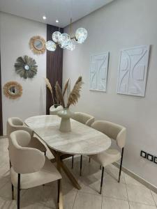 a dining room with a white table and chairs at Appartement à 10 min de la mer à pied in Casablanca