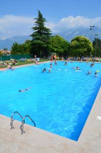 a group of people swimming in a large swimming pool at Schöne Ferienwohnung mit herrlichem Seeblick in Tignale