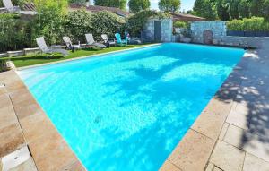 a swimming pool with blue water in a yard at Zèbre in Eyragues
