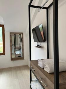 een slaapkamer met een spiegel en een tv op een dressoir bij Vila 30 in Pogradec