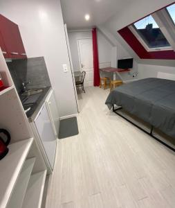 studio indépendant 800 m de la gare du Mans في لو مان: مطبخ وغرفة نوم مع سرير وطاولة