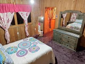 - une chambre avec un lit et un grand miroir dans l'établissement Hermosa cabaña vista al bosque, à La Marquesa
