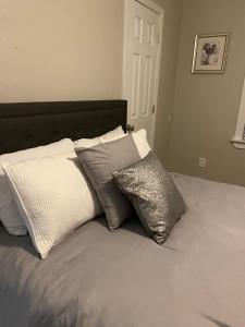 a bed with four pillows on top of it at Charming City Bungalow in Jacksonville