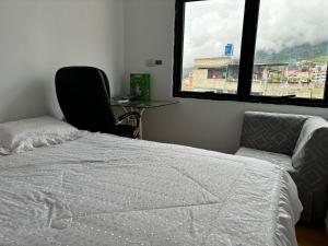 1 dormitorio con 1 cama, 1 silla y 1 ventana en Tu hogar en Abancay, en Abancay