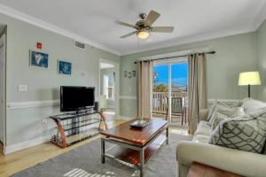 a living room with a couch and a tv at 2 Bed Condo Walk to the Beach in Tybee Island