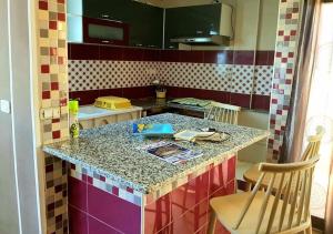 a kitchen with a colorful counter top with two chairs at The Marsa story in La Marsa