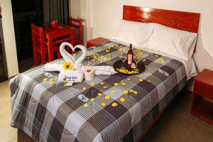 YURAQ WASI Hotel/Restobar في هانوكو: سرير مع صينية طعام وزجاجة من الشمبانيا