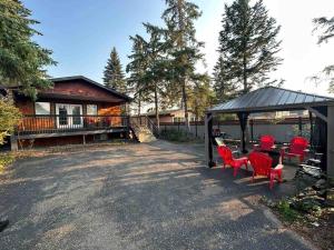 西爾萬湖的住宿－Jasper House，房屋设有凉亭、红色椅子和桌子