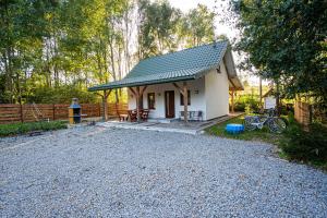 une petite maison blanche avec un toit sur une allée en gravier dans l'établissement Domek u wrót Bieszczad, à Trepcza