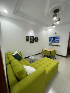 自由市的住宿－Superbe appartement meublé en résidence LBV，客厅配有绿色沙发和桌子