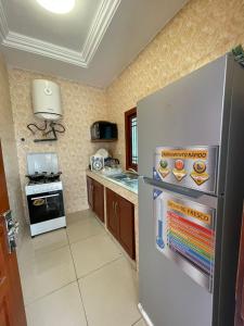 Il comprend une cuisine équipée d'un réfrigérateur en acier inoxydable et d'une cuisinière. dans l'établissement Superbe appartement meublé en résidence LBV, à Libreville