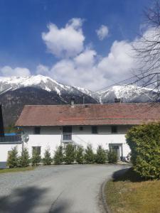 een wit gebouw met sneeuw bedekte bergen op de achtergrond bij Haus Seewald in Passriach