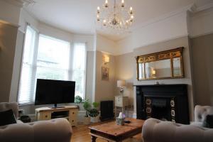 sala de estar con TV y chimenea en orwell villa elegant period 5 bed close to town sleeps 15, en Cheltenham