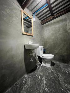 uma casa de banho com um WC e um espelho na parede em Chill House Hostel em Anuradhapura