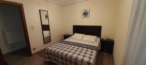 een slaapkamer met een bed en twee foto's aan de muur bij Apartamentos Maliayo Villaviciosa in Villaviciosa