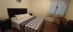 een slaapkamer met een bed met een zwart-wit dekbed bij Apartamentos Maliayo Villaviciosa in Villaviciosa