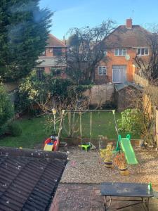 um quintal com um baloiço e um parque infantil em Adam Guest House em Leicester