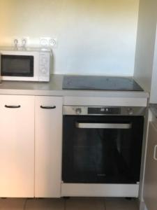 a kitchen with a microwave and a black oven at Chambre double proche Arena La Defense in Nanterre