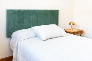 1 dormitorio con cama blanca y cabecero verde en Encanto en Arco Elvira Centro junto a Catedral, en Granada