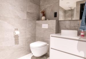 a bathroom with a white toilet and a sink at New luxury cabin near Henningsvær Lofoten in Kleppstad