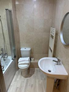 a bathroom with a toilet and a sink at Stratford Apartment - walk to ABBA Voyage in London