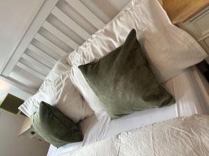 a bed with a green pillow on top of it at Stratford Apartment - walk to ABBA Voyage in London
