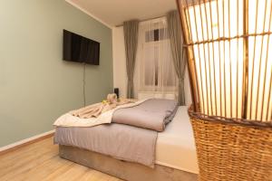 ein kleines Bett in einem Zimmer mit Fenster in der Unterkunft Koala Apartment mit 500 Mbit's WLAN und Balkon in Leipzig