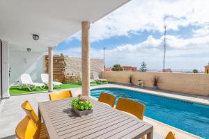 a patio with a table and chairs and a swimming pool at CASA LOS TEJALES with climatized private pool in El Médano