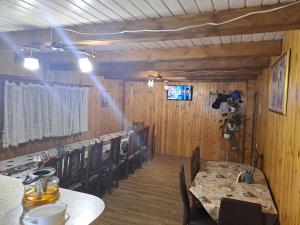 a dining room with tables and chairs and a television at Лимонний дім in Pilipets