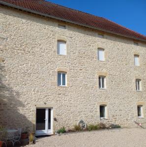 ein großes Backsteingebäude mit Fenstern und einer Tür in der Unterkunft Chambres d'Hôtes Le Moulin à Epices in Chargey-lès-Gray