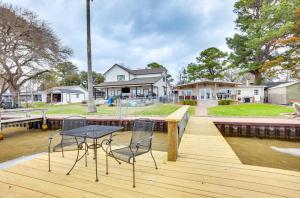 een tafel en stoelen op een houten terras met water bij Lakefront Livingston Retreat with Dock and Fire Pit! in Blanchard