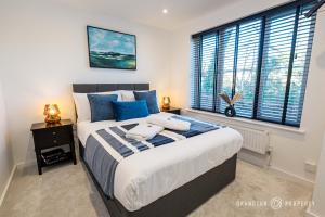 a bedroom with a large bed with blue pillows at Elegant townhouse, Westbourne, Sleeps 8, Parking - The Hideaway in Bournemouth