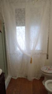 La salle de bains est pourvue d'une fenêtre avec un rideau blanc. dans l'établissement Il Sole, à Rimini
