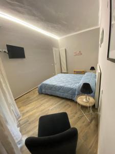 een kleine slaapkamer met een bed en een stoel bij La casa nel Vicolo Camera 1 in Casale Monferrato