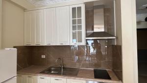 a kitchen with white cabinets and a sink at Oasis Beach Residence in Vlorë