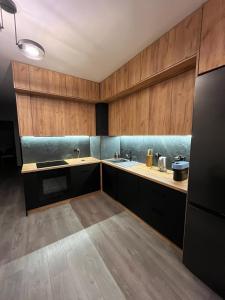 a kitchen with wooden cabinets and a sink and a stove at WORKATION Centre Airport Boutique Designer Bath, 3-4 days best offer, Kitchen, Balkony, Aircon in Warsaw