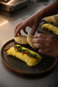 a person is reaching for a plate of food at Casa TO in Puerto Escondido