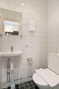 a bathroom with a sink and a toilet and a mirror at Brunnby Hotel in Stockholm