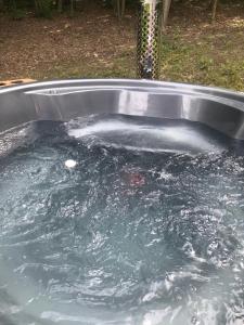 a pool of water in a metal tub at Domek w lesie Sauna i Gorąca balia Wellness&Spa in Grybów