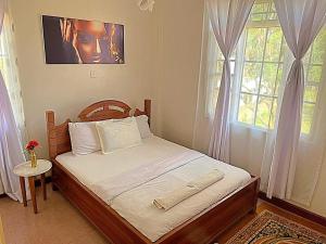 a small bed in a bedroom with a window at Homely apt 3 (three) in Kisumu